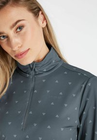 Grijze kwart-rits pullover met een zachte textuur, voorzien van een subtiel driehoekpatroon en een staande kraag. "Protest" logo op de borst.