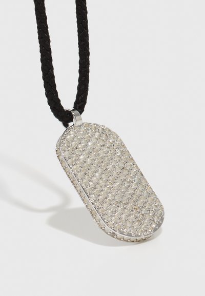 Collana con pendente in argento, con una superficie rettangolare e testurizzata coperta di piccoli strass, appesa a un cordino nero intrecciato.
