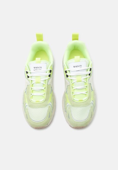 Ζευγάρι sneakers Maison Kitsuné χαμηλού πάτου σε ανοιχτό πράσινο και άσπρο χρώμα με πάνελ από δίχτυ και σουέτ, λευκά κορδόνια και ετικέτες με το λογότυπο στη γλώσσα.