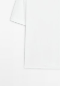 White short-sleeve t-shirt featuring a relaxed fit, smooth texture, and a clean hemline. No visible patterns or graphics.