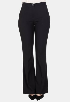 Pantaloni neri a vita alta e gamba larga con chiusura frontale con bottoni e zip, indossati con scarpe nere punta a punta su sfondo bianco.
