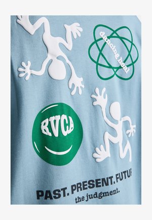 Dve biele abstraktné postavy a zelený kruh s nápisom "RVCA" na modrej látke, zelený atómový symbol s nápisom "dancing heal" a text "MINULOSŤ. PRÍTOMNOSŤ. BUDÚCNOSŤ."