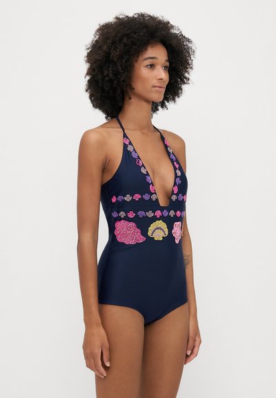 Tengerész stílusú, egyberészes fürdőruha mély V-nyakkivágással, nyakpántos kialakítással, és színes hímzett kagyló- és levélmotívumokkal az elején. Sima textúra.