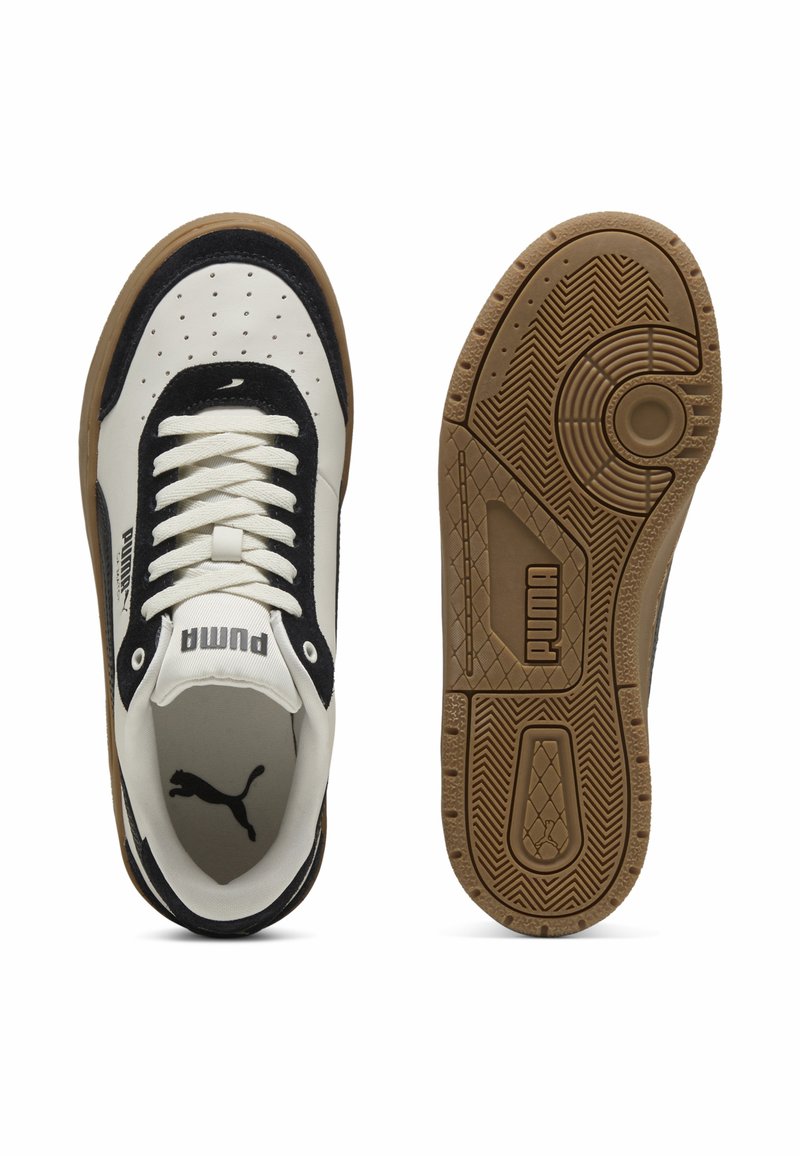 Baskets blanches et noires avec un dessus texturé, fermetures à lacets et semelle en caoutchouc avec un motif de semelle. Logo affiché sur le côté et à l'arrière.