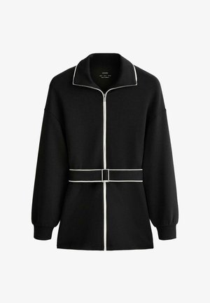 Musta pitkähihaisen vetoketjullinen takki, jossa valkoiset reunukset, korkea kaulus ja vyötäröllä suorakaiteenmuotoinen soljellinen vyö.