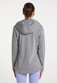Felpa sportiva grigia con una trama morbida e un cappuccio ampio, caratterizzata da una vestibilità rilassata e delicati dettagli cuciti, vista da dietro.