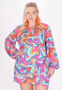 Rochie înfășurată colorată, în nuanțe de albastru, roz, portocaliu și galben, cu un model abstract, mâneci lungi și manșete plisate. Textura țesăturii este netedă.
