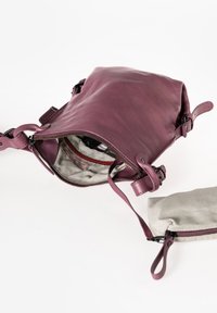 Borsa in pelle viola con chiusura a zip, dotata di una fodera in tessuto a righe. Include un piccolo pouch grigio con zip. Spallacci regolabili.