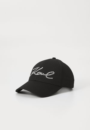 Black baseball cap with a curved brim. Features a shiny rhinestone design spelling "Love" on the front. Made from textured fabric.