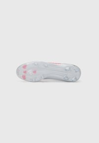 Átlátszó gumitalpú cleats, hat tüskével és piros kiegészítőkkel. Simább, elegáns dizájn, enyhe ívvel az orr részen.