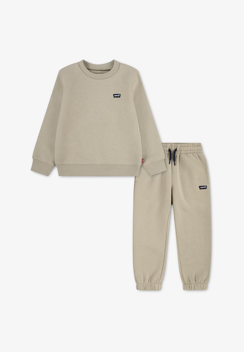 Ensemble pour enfants avec sweat beige et pantalon à taille élastique, poignets côtelés et logos Levi's sur la poitrine et la cuisse.