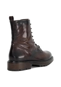 Bruine leren enkelboot met een ronde neus, vetersluiting aan de voorkant en een gestructureerd oppervlak. Rubberen zool met gripdetails en een lus om aan te trekken.