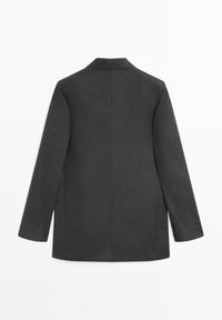 Donkergrijs, langermig, onafgeknipte blazerjack gezien van achteren op een witte achtergrond.