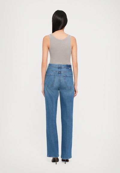 Light gray ribbed tank top paired with high-waisted, loose-fitting blue denim jeans featuring two back pockets and minimal stitching details.