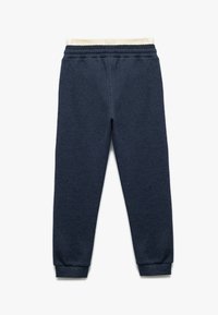 Marineblaue Sweatpants aus strukturiertem Material, mit elastischem Bund und Bündchen am Saum. Sie verfügen über ein weiches, cremefarbenes Innenfutter.