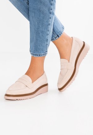 Light pink suede loafers with a wedge sole, featuring a stitched band across the upper and contrasting brown trim along the edge.