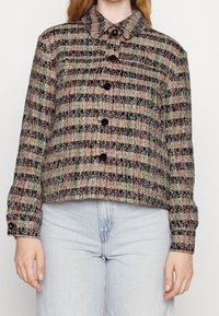 Woven wool jacket featuring a cropped design, multicolored check pattern in gray, black, and pink, with a collar and black buttons.