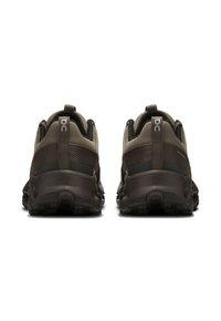 Des chaussures de sport marron avec une tige en mesh, un col rembourré et une semelle extérieure texturée, dotées d'un système de laçage rapide et d'un détail de logo au niveau du talon.