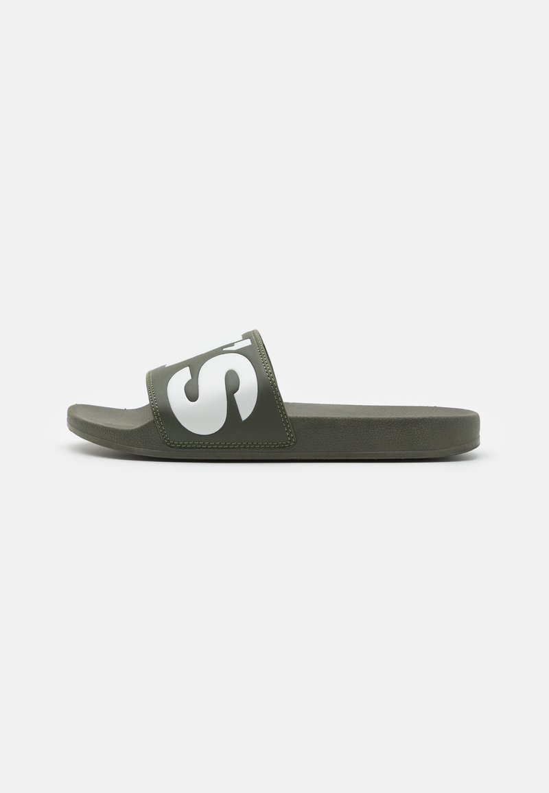 Sandale verte à semelle plate avec une large sangle ornée d'un design de logo blanc, semelle texturée et finition mate lisse.