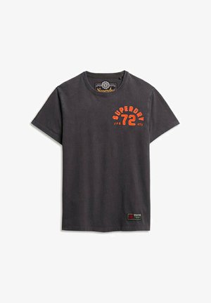 Szara koszulka z krótkim rękawem, wykonana z bawełny, z pomarańczowym napisem "SUPERDRY 72" z przodu oraz małą naszywką z logo na dole.