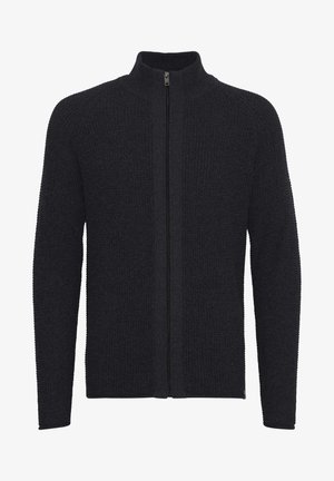 Mørk strikkegenser med høy krage og full glidelås foran. Teksturert stoff, lange ermer og rett snitt. Ingen synlige mønstre eller aksenter.