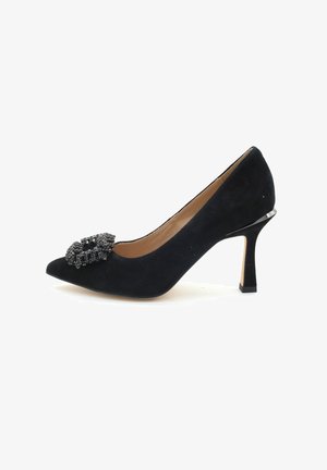 Chaussure à talons hauts en daim noir avec un bout pointu et un détail de boucle orné sur le dessus. Présente un accent métallique élégant sur le talon.