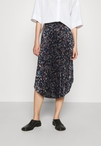 Černá midi sukně s plisováním, zdobená květinovým vzorem v modré, fialové a bílé barvě. Doplněná černými slip-on botami a bílým topem.