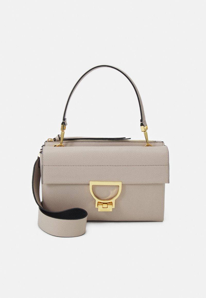 Beżowa skórzana torebka z ustrukturalizowanym klapkiem, złotym zapięciem, uchwytem u góry oraz odpinanym szerokim paskiem na białym tle.