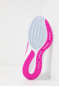 Suola della scarpa caratterizzata da una parte superiore bianca con un design testurizzato, intersuola azzurro chiaro e suola esterna rosa brillante con scanalature per la trazione.