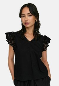 Top noir avec un décolleté en V, manches courtes ornées d'une délicate bordure en dentelle, fabriqué en tissu léger, coupe décontractée.
