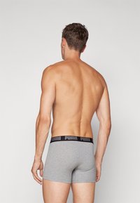 Gray boxer shorts with a black PUMA logo waistband, smooth texture, and snug fit, viewed from the back.