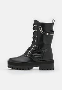 Czarne skórzane buty bojowe z przodem wiązanym na sznurówki, podwójnymi srebrnymi zapięciami, boczną kieszenią na zamek błyskawiczny oraz grubą gumową podeszwą z rowkowanym wzorem.