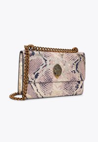 Sac bandoulière à motif serpent en rose, beige et noir avec une chaîne dorée et un fermoir décoratif en forme de feuille. Surface texturée.