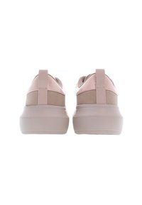 Paire de baskets rose clair avec semelles épaisses vue de dos sur un fond blanc.