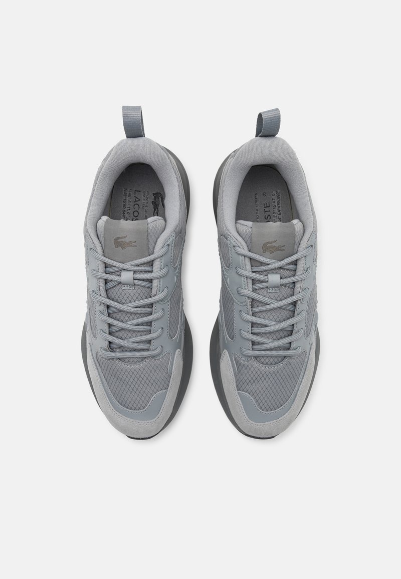 Szare buty sportowe wykonane z siateczki i zamszu, o okrągłym czubku, teksturowanym wzorze oraz kontrastującej czarnej podeszwie. Dwie pętle na kołnierzu.