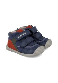 Scarpe alte blu navy in pelle, caratterizzate da dettagli rossi e verdi, due cinturini in velcro regolabili e una suola in gomma grigia testurizzata.