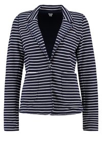 Blazer bleu marine avec des rayures horizontales blanches, fermeture à un bouton noir, deux poches avant et col à revers.