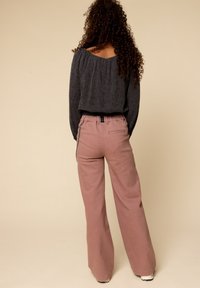 Grijs kort sweatshirt met een gathered halslijn, gecombineerd met lichtroze high-waisted wijde pijpenbroek met een elastische tailleband en achterzak.