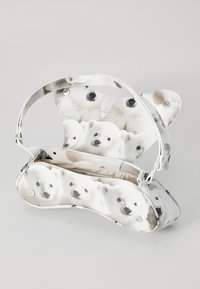 Sac à main blanc avec un imprimé ours polaire. Le sac a une forme incurvée, une texture lisse et une bandoulière ajustable avec des oreilles arrondies sur le dessus.