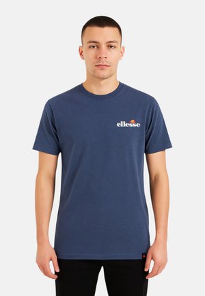 T-shirt en coton bleu marine avec un col rond, des manches courtes, et un logo blanc "ellesse" accompagné d'un détail graphique rouge et orange.