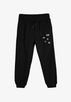 Pantalones de chándal negros hechos de un tejido suave, con texto blanco que dice "PERMANECE POSITIVO" en diversas disposiciones. Incluye bolsillos laterales y tobillos elásticos.