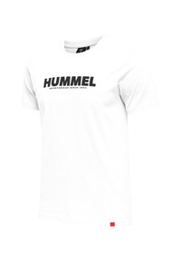 T-shirt en coton blanc à manches courtes, avec un imprimé noir audacieux "HUMMEL" et le texte "sportswear since 1923" en dessous. Accent rouge en bas.