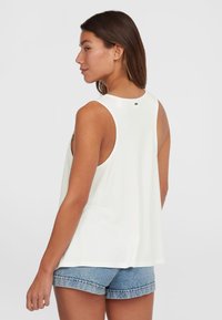 Top bianco senza maniche realizzato in materiale morbido, con una vestibilità ampia e un orlo curvo, abbinato a pantaloni short in denim. Design minimalista.