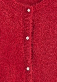 Roter Cardigan aus flauschigem Strickmaterial, mit fünf weißen perlenähnlichen Knöpfen vorne und einem runden Ausschnitt.