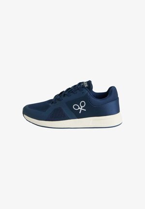 Zapatilla deportiva azul marino con suela blanca, diseño con cordones y un logo estilizado blanco en el lateral.