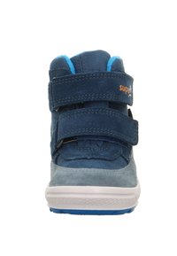 Modrá semišová vysoká teniska se dvěma suchými zipy a bílou gumovou podrážkou. Vnitřek je vybaven jasně modrou podšívkou.