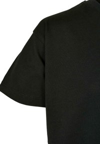 T-shirt en coton noir à manches courtes. Doté d'un col rond et d'un ourlet droit. Texture lisse avec une seule couleur unie et sans motifs.
