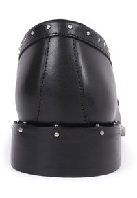 Black leather shoe featuring a rounded design, silver studs along the top edge, and a flat wooden sole with a slightly raised heel.