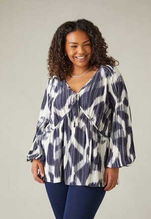 Marineblauwe en witte blouse met een patroon, voorzien van een v-hals, plooien onder de buste en lange, wijd vallende mouwen. Gladde textuur met een lichte glans.