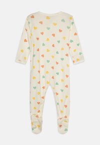 Hosszú ujjú rugdalózó krémszínű pamutból, amelyet színes szívminták díszítenek rózsaszín, sárga, zöld és narancssárga színekben. Talpas kivitel.